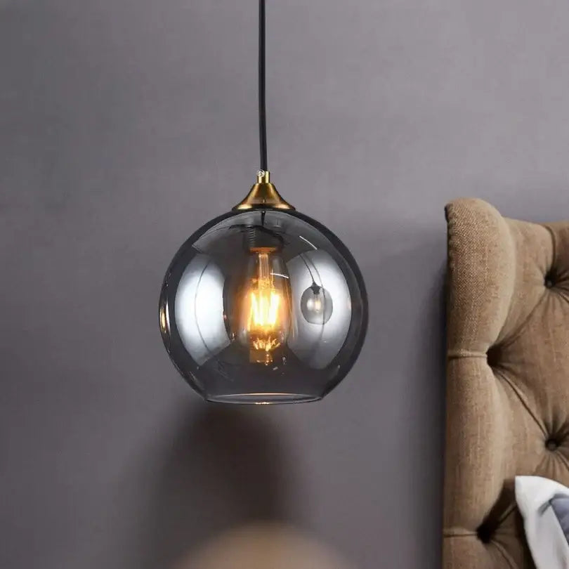 Modern smoked glass ball pendant light with brass top and exposed filament bulb for kitchen and dining decorbites glass ball