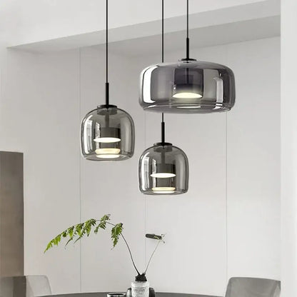Three modern pendant lights with smoked glass bowl shades and black metal fixtures for dining room chandelier lighting