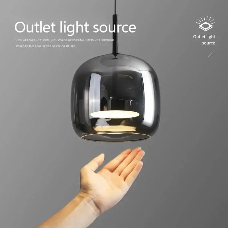 A modern smoked gray glass led pendant chandelier with a sleek rounded design and warm-toned bulb for dining room