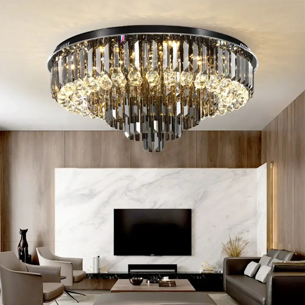 A modern smoky gray and gold decorbites crystal led chandelier with black metal frame and cascading crystal prisms