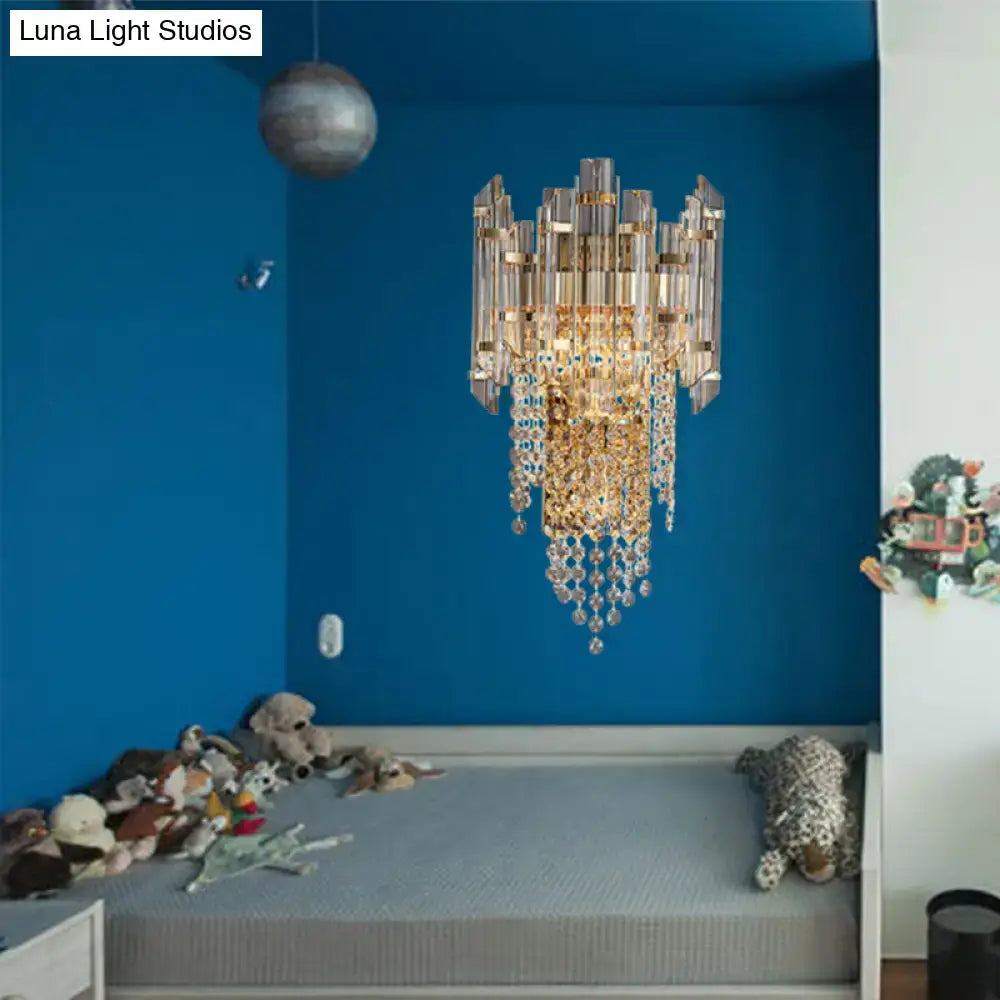 Modern smoky grey crystal wall sconce with gold-toned metal arms and cascading clear crystal droplets for living room lighting