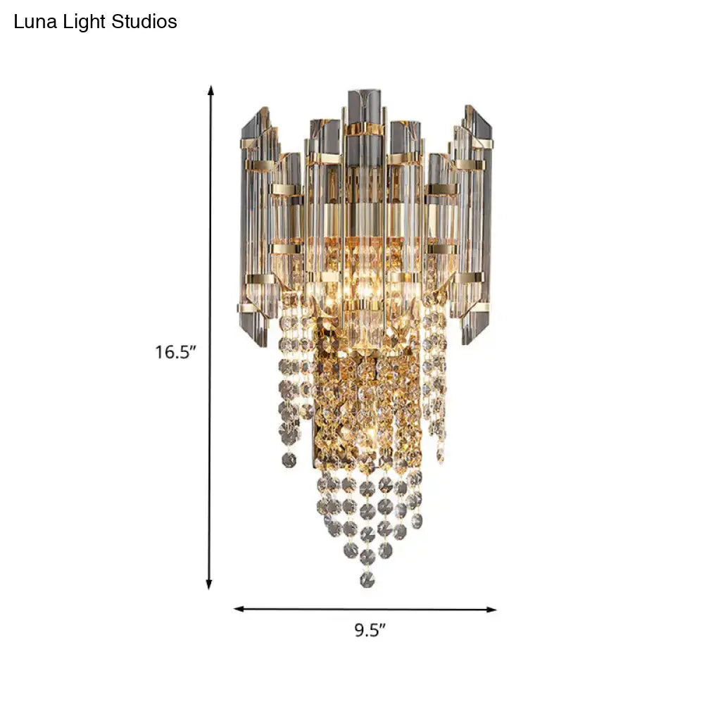 Modern smoky grey crystal wall sconce featuring a gold and clear crystal chandelier with a cascading design for living rooms