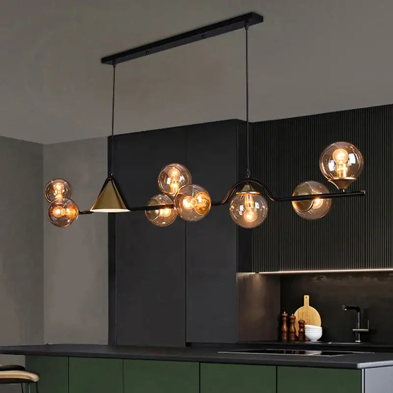 Modern black metal pendant light with smoky grey glass globes and gold-toned triangular accent for dining room