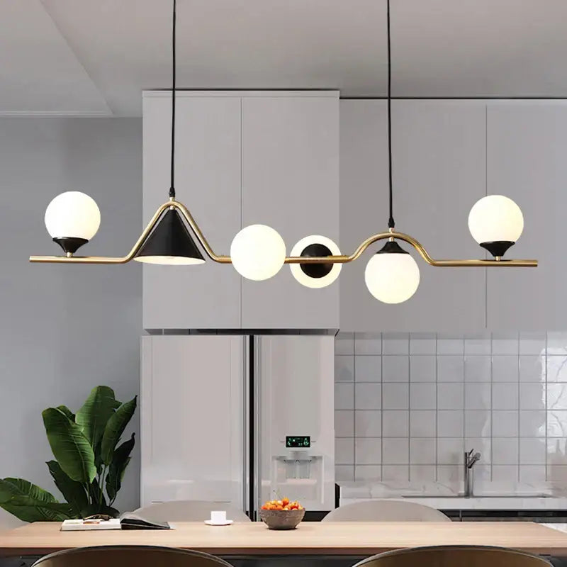 Modern smoky grey glass pendant light with five frosted globes on brass and black metal frame for dining room
