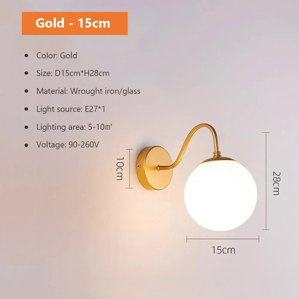 Modern spherical glass shade gold wall lamp with curved wrought iron arm and round glass globe for bedroom use