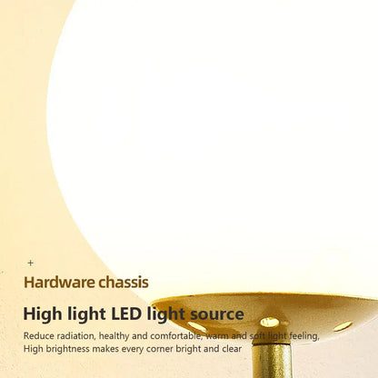 A modern wall lamp with a frosted white spherical glass shade and brushed gold metal base for bedroom use