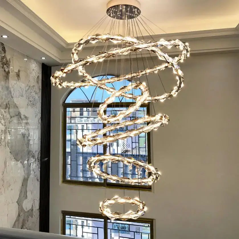 A modern spiral decorbites crystal chandelier with glowing clear faceted crystal rings for living room lighting