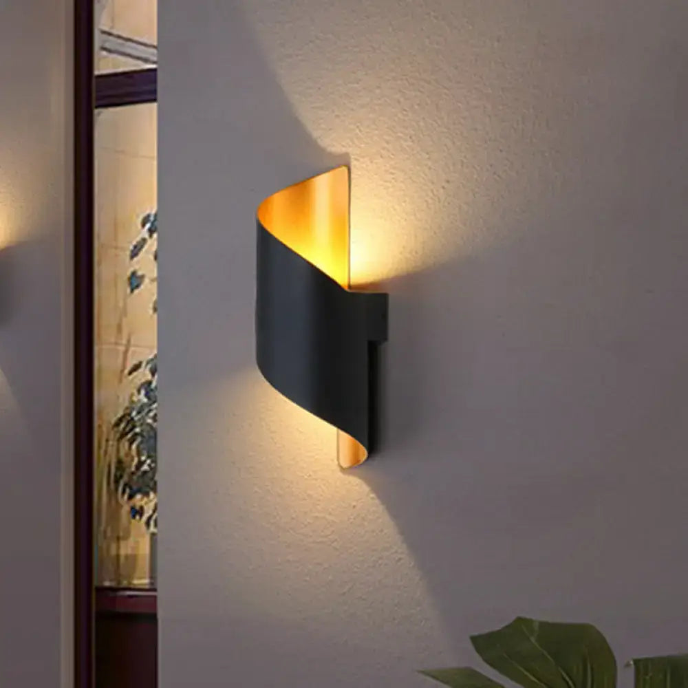 Modern black and gold direct wired wall sconce with a sleek curved design for bedroom lighting use