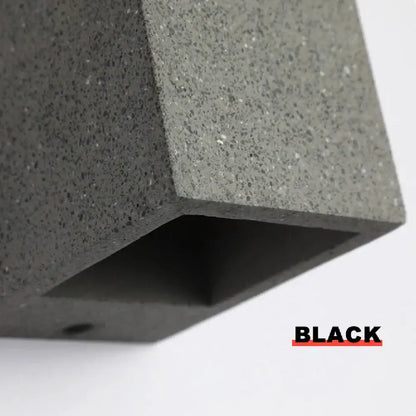 Black textured concrete outdoor wall lamp with matte finish and speckled surface decorbites cement wall sconce