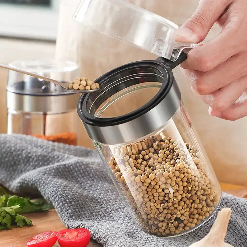 Modern stainless steel and glass seasoning pot filled with white peppercorns for kitchen supplies use