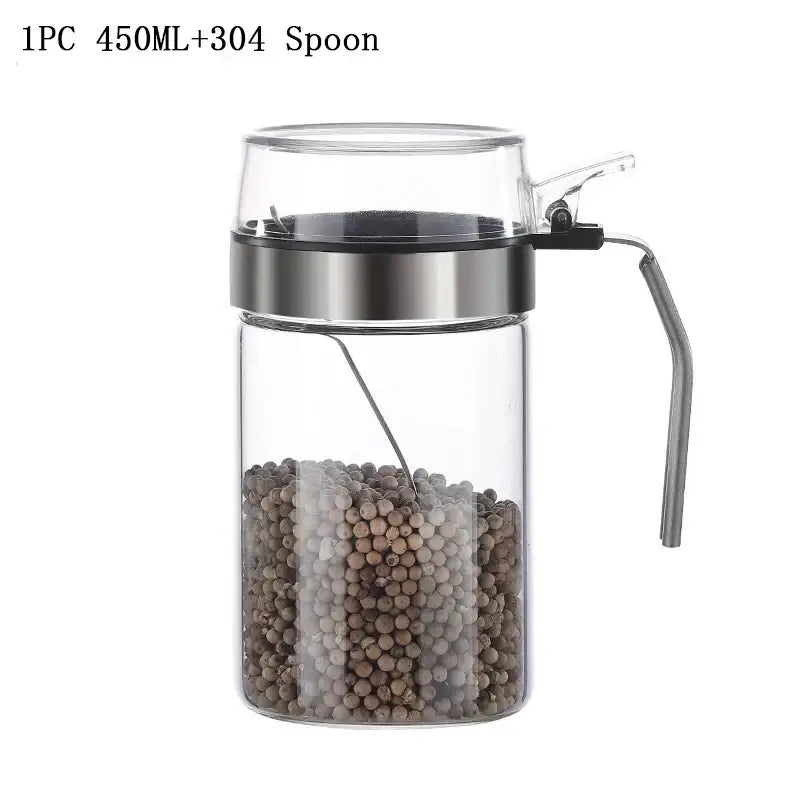 Clear glass seasoning pot with stainless steel lid and handle containing black and white peppercorns for kitchen supplies