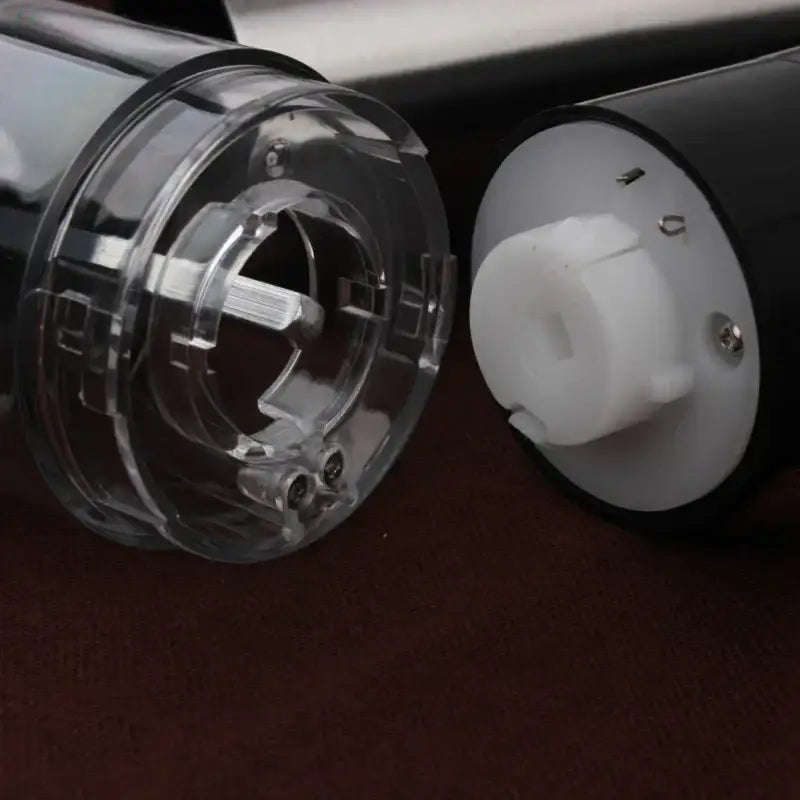 Clear plastic and white components of a modern stainless steel electric salt pepper grinder housing for kitchen use