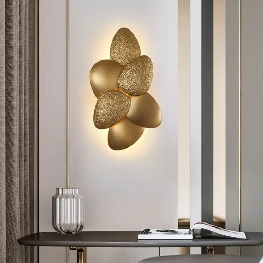 Gold-toned modern stainless steel squama wall light with textured petal design for bedroom sconce lighting