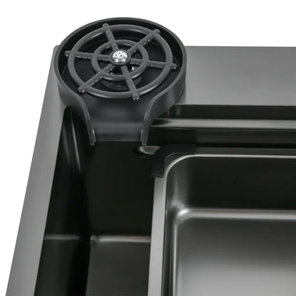 Black plastic drip tray with circular spoke design and central drainage hole for modern stainless steel kitchen sink