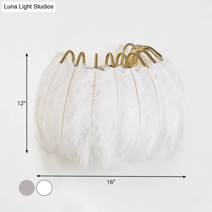 Modern style grey white sconce light featuring white feathered pumpkin design with gold toned metal hooks for wall decor