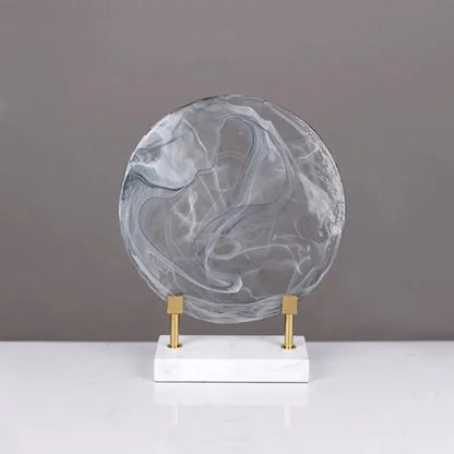 Modern swirling glass geometric disk home decor figurine in translucent gray and white marble on minimalist marble base