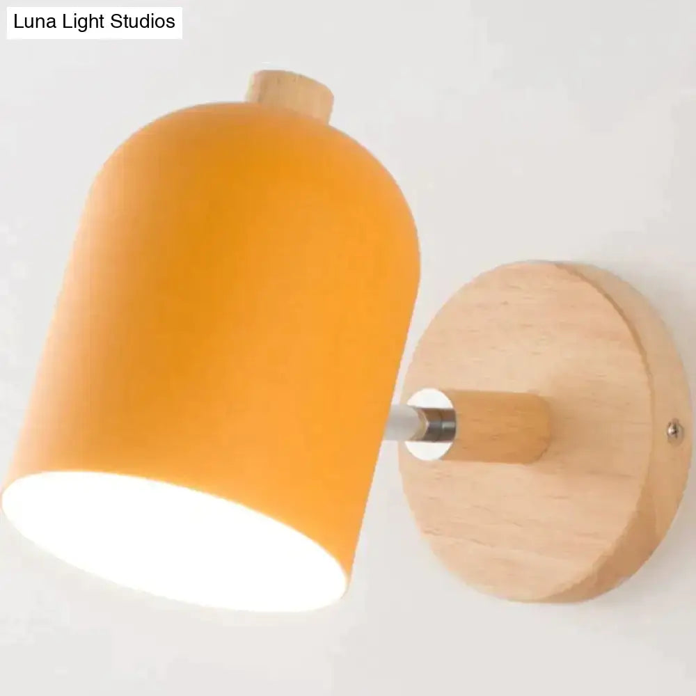 Modern teal and wood wall lamp with warm orange cylindrical lampshade mounted on light wood circular wall plate