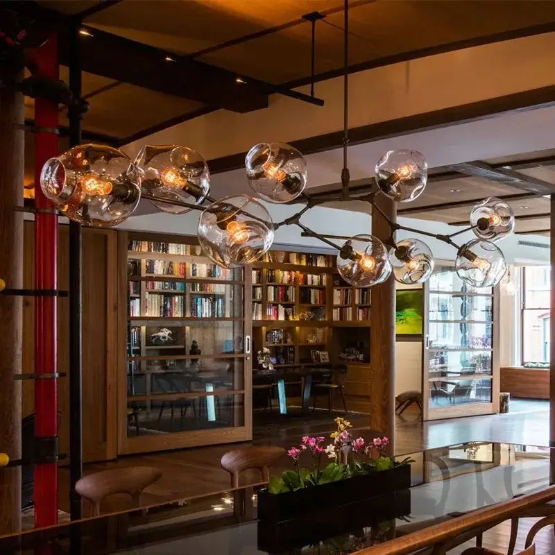 Modern teal glass bubble branch chandelier with exposed filament bulbs and dark metal structure for dining room decorbites glass bubble