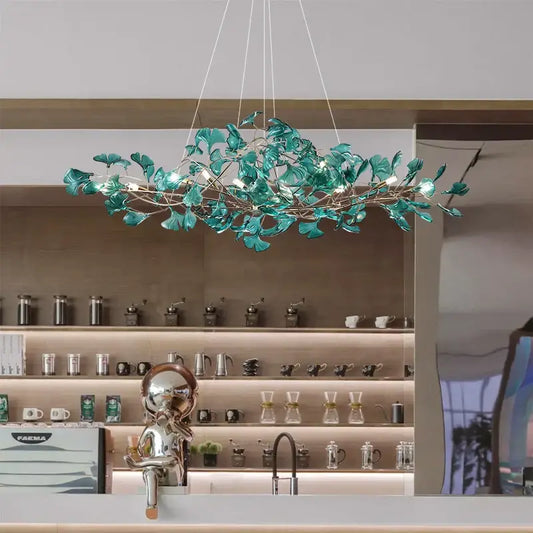 A modern teal glass gingko leaf chandelier with integrated lighting for dining room decorbites gingko leaf decor