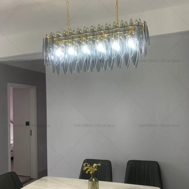 Modern teal and gold glass chandelier light with cascading translucent glass leaves for living room lighting