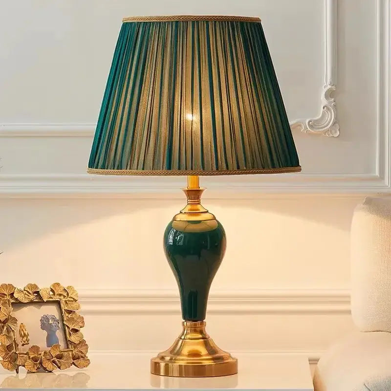 Elegant modern teal green ceramic table lamp with gold-toned accents and pleated shade for bedroom and living room