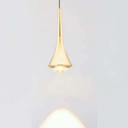 A sleek gold teardrop pendant light with black and white cord pendant light design for dining room use