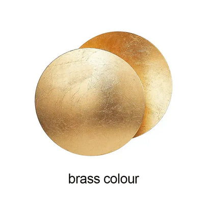 Modern textured eclipse round wall lamp featuring two overlapping brushed brass discs for bedroom lighting