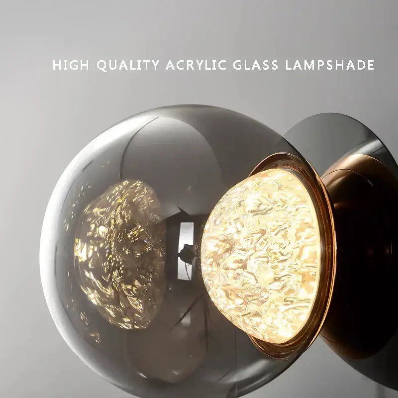 Modern textured glass ball sconce lamp with a translucent smoke-gray acrylic shade and polished brass rim for bedroom decorbites sconce lamps