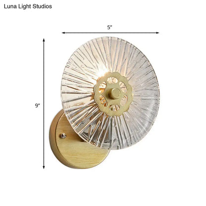 Modern textured gold wall lamp with clear crystal sconce, brass gear design, and wooden backplate for bedroom lighting