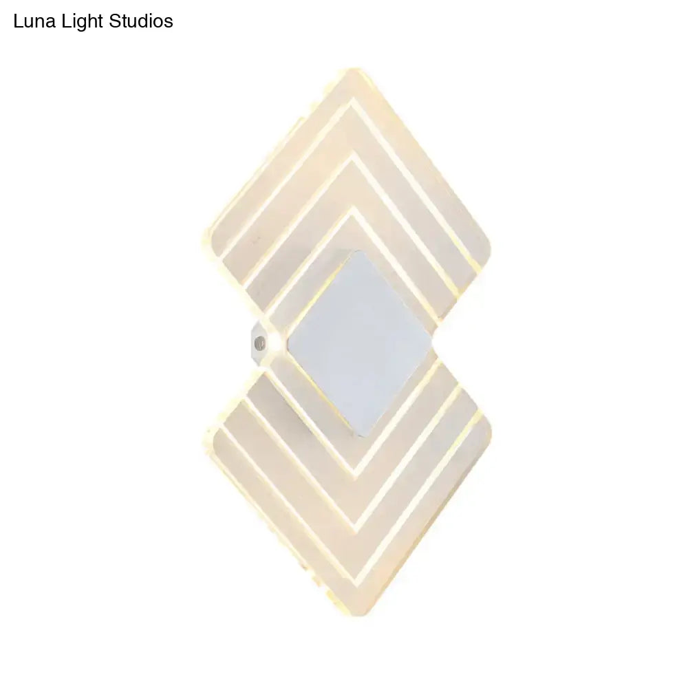 Modern textured silver and black direct wired electric wall sconce with diamond layered geometric design and warm LED lighting