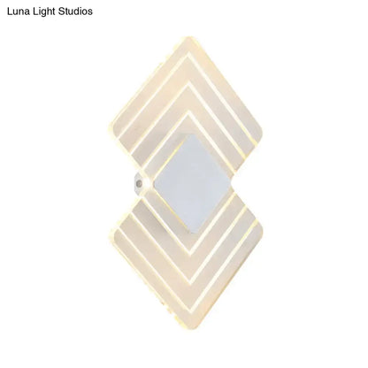 Modern textured silver and black direct wired electric wall sconce with diamond layered geometric design and warm LED lighting