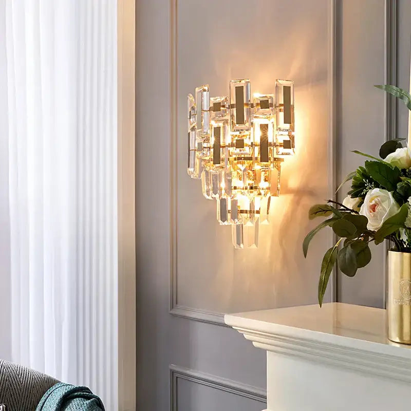 Modern crystal wall lamp with gold-toned metal frame and asymmetrical clear faceted glass decorbites crystal wall lamp