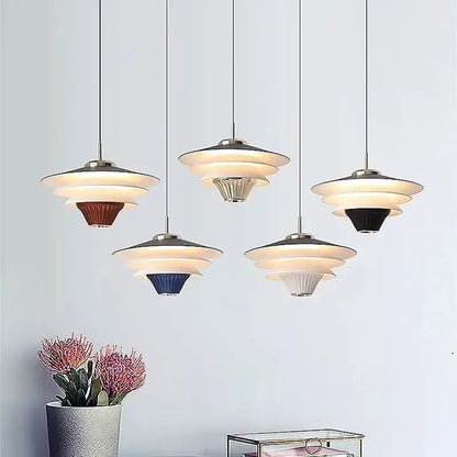 Modern tiered pendant lights with cream wind milk glass shades and metallic accents in brown blue black white and silver
