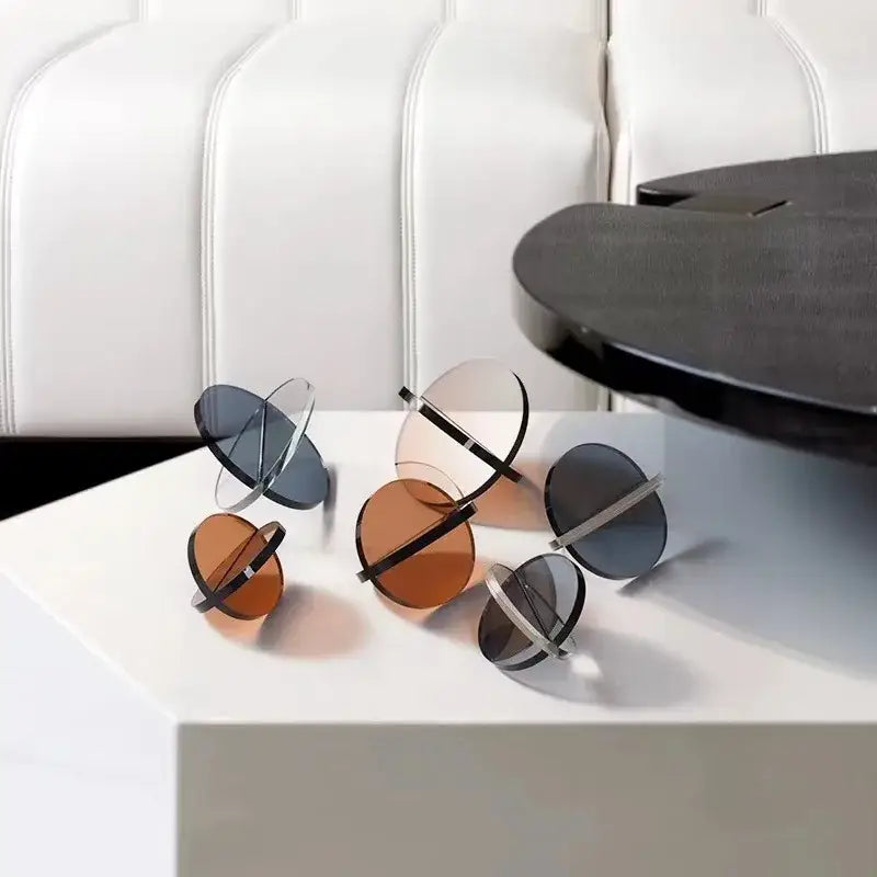 Modern geometric sunglasses with translucent amber and dark gray lenses and black metal arms for decorbites intersect glass ball semicircle living room decor