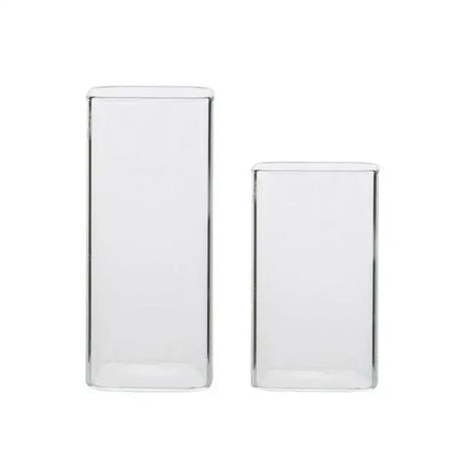 Two clear transparent glass square measuring cups in rectangular vases for kitchen and dining use