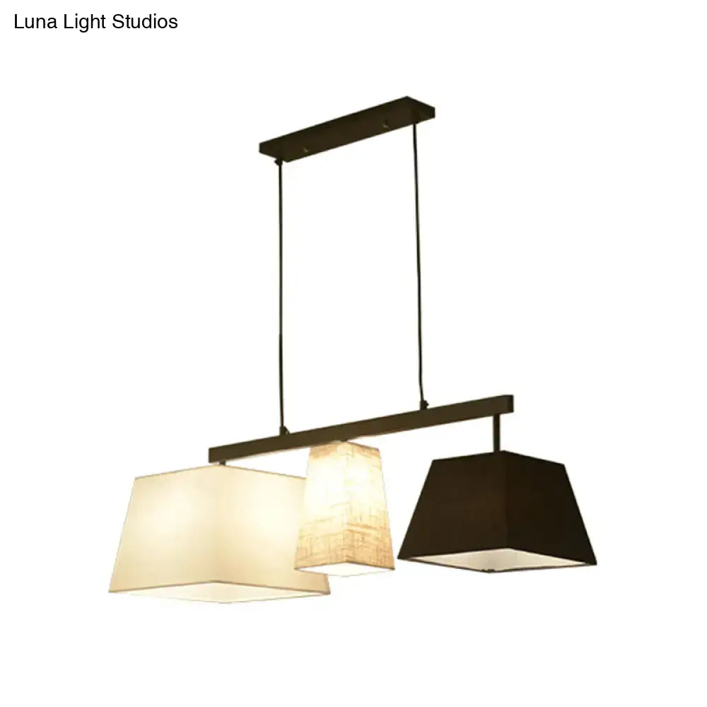 Modern DecorBites™ trapezoid fabric hanging lamp with dark metal frame and three cream beige and black shades for island light use