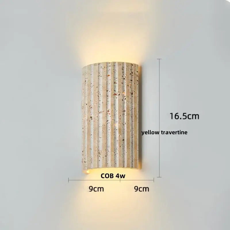 A modern decorbites led wall light in natural yellow travertine with warm ambient glow for bedroom reading lamp