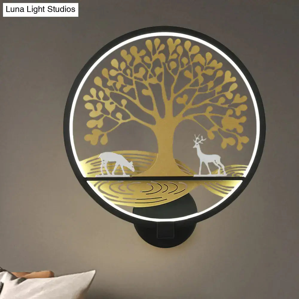 Modern wall lamp with a circular led sconce featuring a golden tree of life design and white deer silhouettes