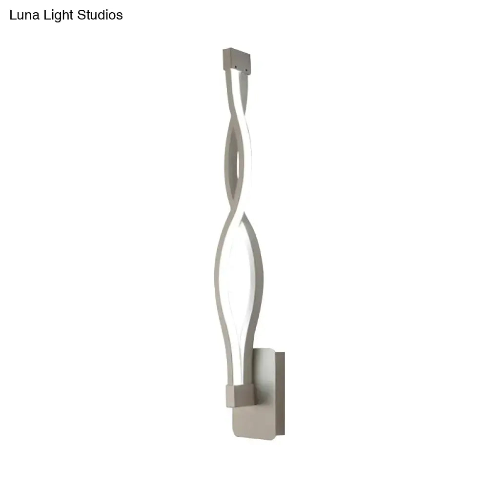 Modern silver-toned led wall sconce with a sleek twisted design and minimalist rectangular mounting plate for bedroom light