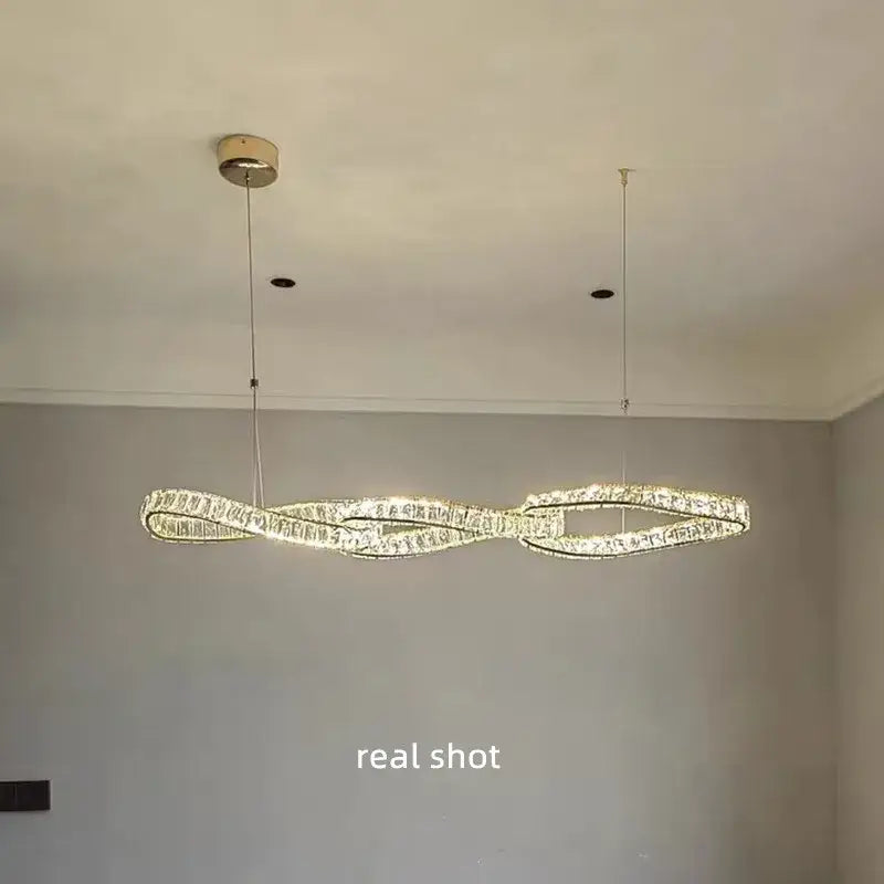 Modern twisted gold metal crystal pendant light featuring infinity-loop design with warm led for dining room decorbites gold metal crystal