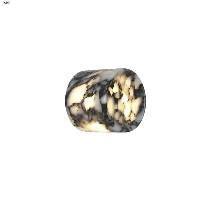 Modern wabi sabi black and cream resin led wall lamp with a cylindrical translucent bead and marbled swirling pattern