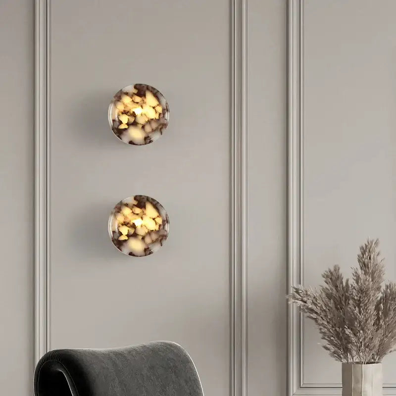 Two modern wabi sabi black and cream resin led wall lamps with marbled amber and dark brown tones for bedroom lighting