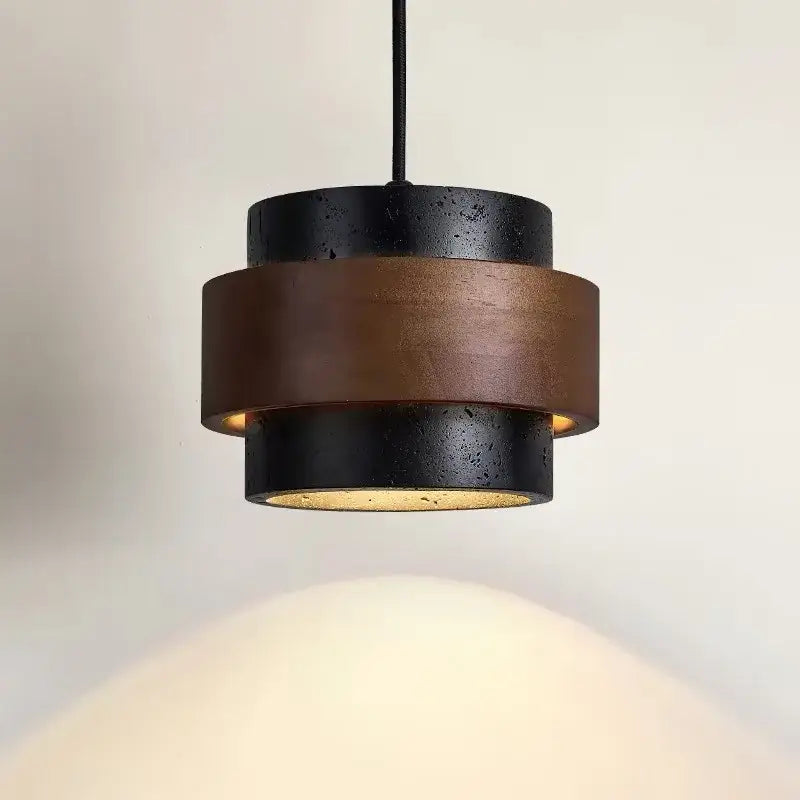 Modern wabi sabi tiered stone pendant light with black and bronze layers and textured concrete finish for dining room