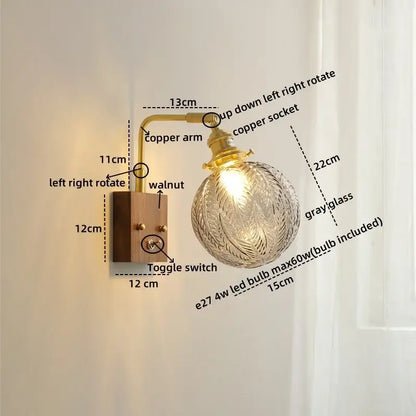 Modern walnut copper wall sconce with clear gray glass globe and ornate leaf etchings for stair lighting