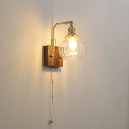 Modern walnut copper wall sconce with clear ribbed glass globe and wooden base for stair lighting