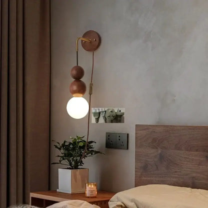 Modern walnut wood and white glass wall light with brass curved arm and stacked wooden spheres for adjustable led wall decorbites