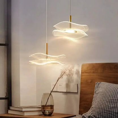Two modern led pendant lights with translucent wave glass shades and gold fixtures for dining tables or living rooms