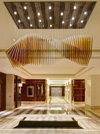 A modern wave golden designer chandelier with sleek reflective metal panels for dining room decorbites designer chandelier