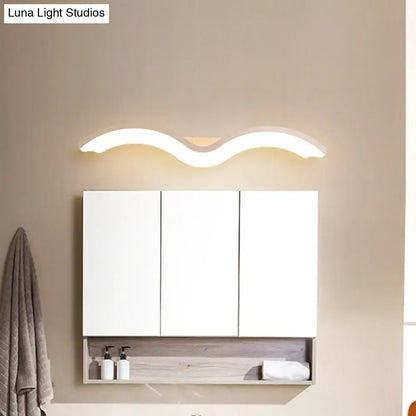 White three-door bathroom cabinet with a modern wavelet black and white wall sconce led light fixture above it