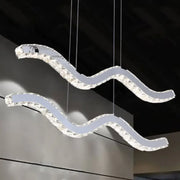 Modern crystal-encrusted wave-shaped hanging light fixture with stainless steel frame for minimalistic office use